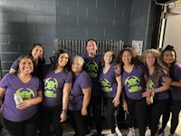 a group of people in purple shirts posing for a picture