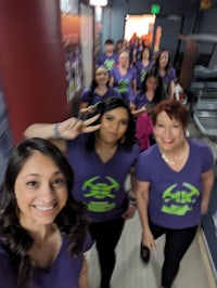 a group of women in purple shirts posing for a photo
