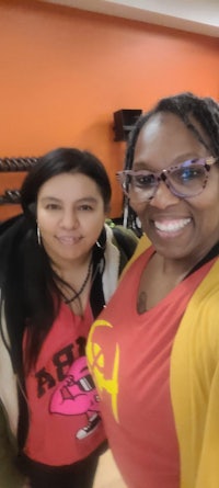 two women posing for a selfie in a gym
