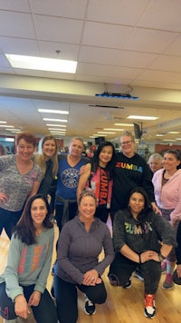 a group of people posing for a photo in a gym