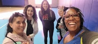 a group of women posing for a selfie in a gym